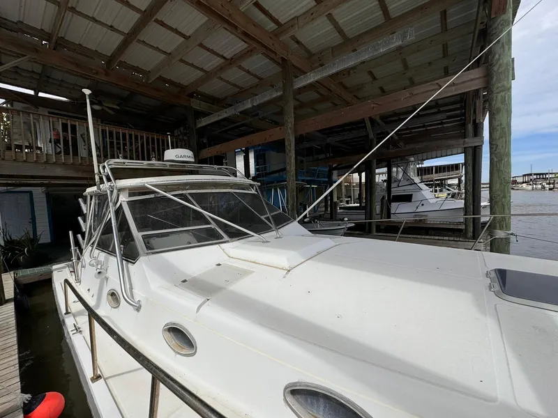 Slide: The Image of 1987 Luhrs Alura boat docked under a covered marina. - 10