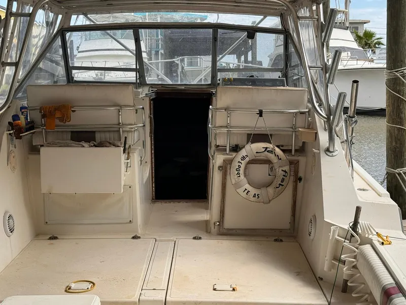 Slide: The Image of 1987 Luhrs Alura boat interior with life ring and docked yachts in background. - 13