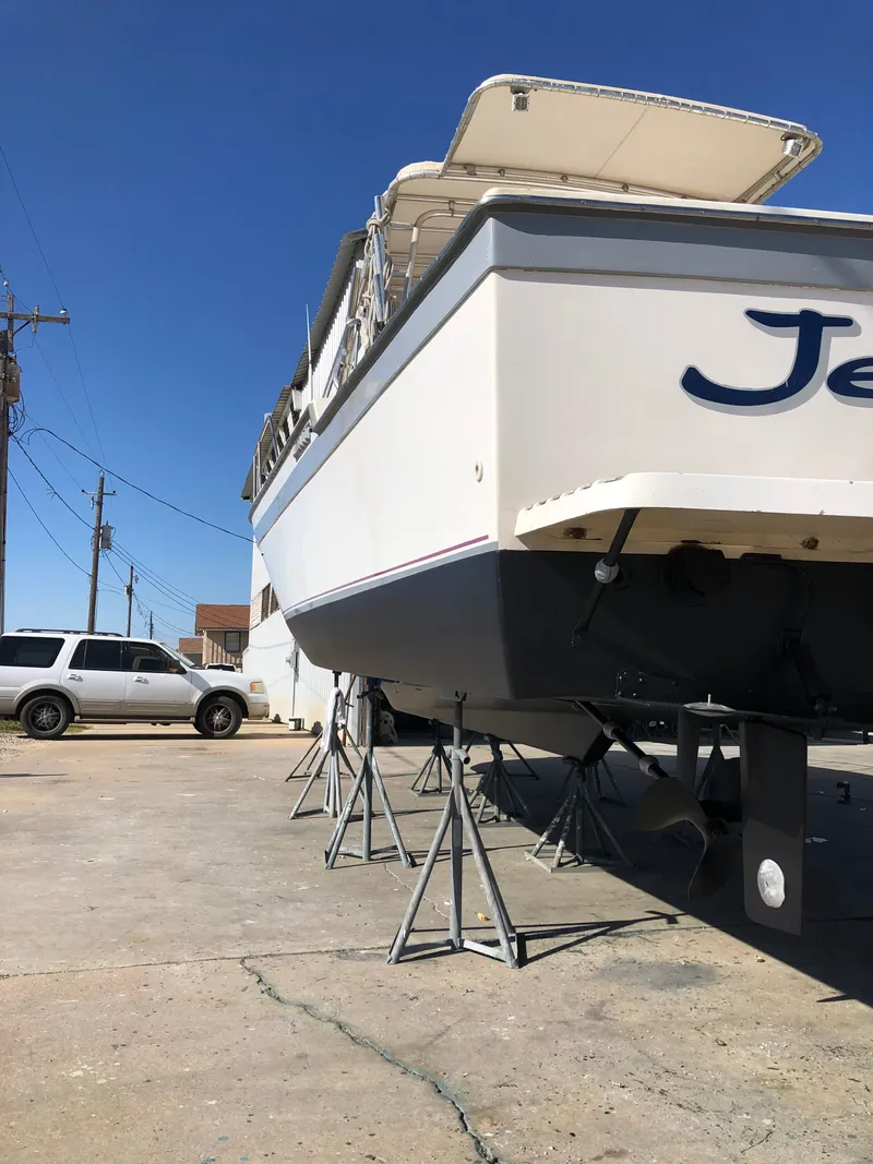 Slide: The Image of 1987 Luhrs Alura boat on stands for maintenance, viewed from the stern. - 2