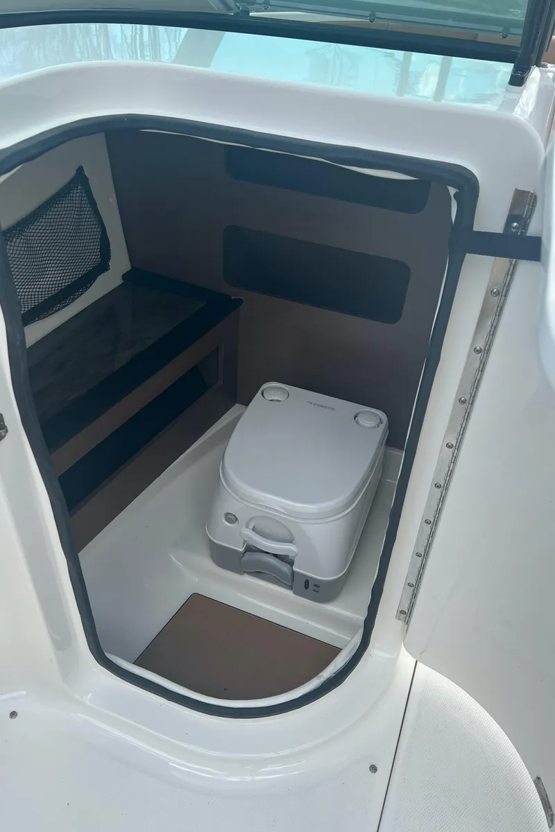 Slide: The Image of 2014 Sea Ray 240 Sundeck Outboard boat interior with portable toilet. - 12