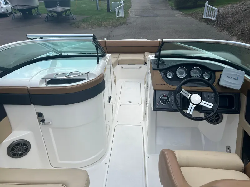 Slide: The Image of 2014 Sea Ray 240 Sundeck Outboard boat interior with steering wheel and seating. - 23