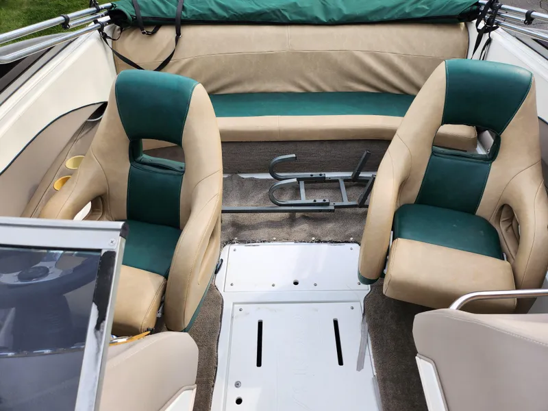 Slide: The Image of Interior of a 1998 Cobalt 200 boat with green and beige seating. - 18