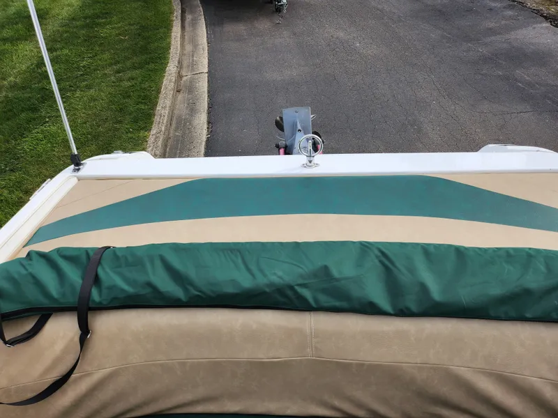 Slide: The Image of 1998 Cobalt 200 boat with green and beige upholstery, parked on a paved road. - 20