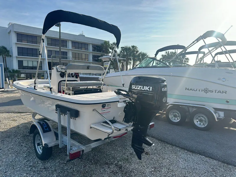 Slide: The Image of 2024 Carolina Skiff E16 JVX CC boat with Suzuki outboard motor on trailer. - 6