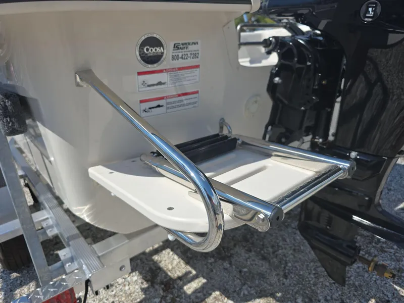Slide: The Image of 2024 Carolina Skiff E16 JVX CC boat with rear swim ladder and outboard motor. - 8