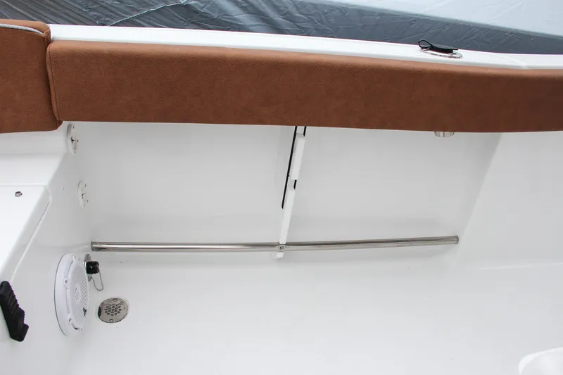 Slide: The Image of 2024 Sea Hunt Ultra 229 boat interior with brown cushioned seating and stainless steel railing. - 23