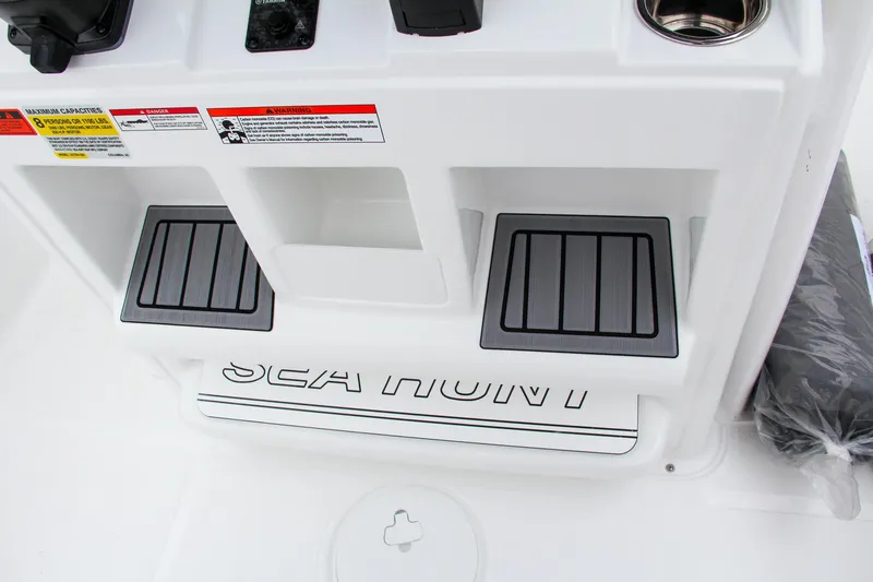 Slide: The Image of 2024 Sea Hunt Ultra 229 boat console with footrests and storage compartments. - 25