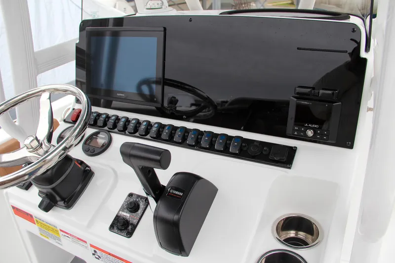 Slide: The Image of 2024 Sea Hunt Ultra 229 boat dashboard with steering wheel, controls, and electronic display. - 29