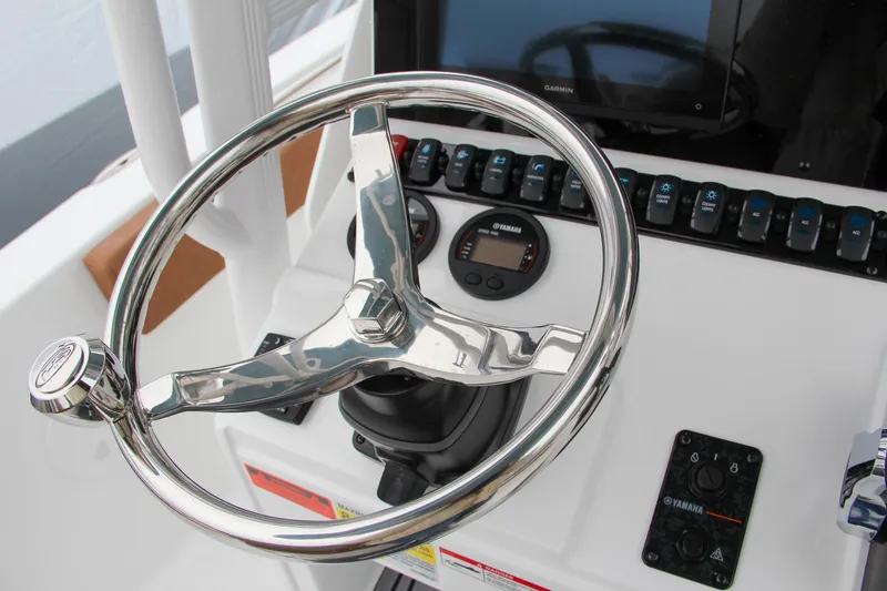 Slide: The Image of 2024 Sea Hunt Ultra 229 boat helm with steering wheel and control panel. - 32
