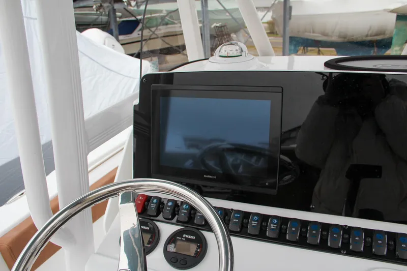 Slide: The Image of 2024 Sea Hunt Ultra 229 boat dashboard with steering wheel and electronic display. - 33