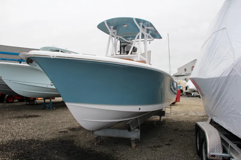 Slide: The Image of 2024 Sea Hunt Ultra 229 boat on display in a marina. - 4