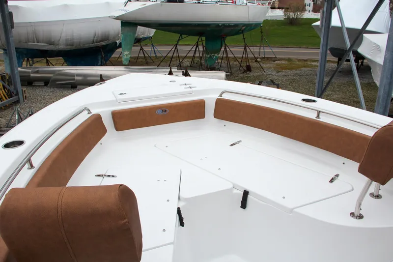 Slide: The Image of 2024 Sea Hunt Ultra 229 boat with brown cushioned seating in a marina. - 43
