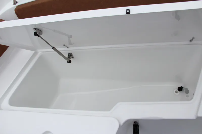 Slide: The Image of 2024 Sea Hunt Ultra 229 storage compartment with open lid. - 45