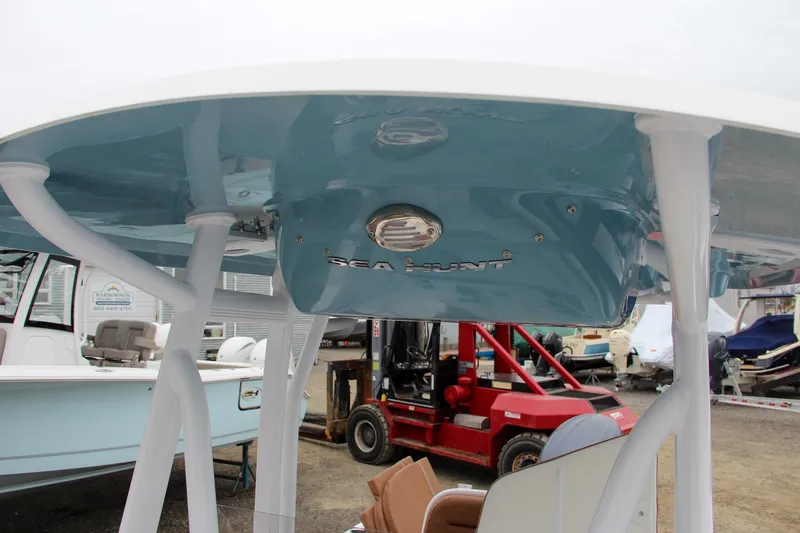 Slide: The Image of 2024 Sea Hunt Ultra 229 boat with blue T-top and white supports. - 48