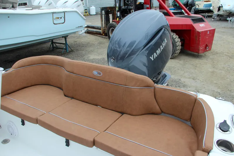 Slide: The Image of 2024 Sea Hunt Ultra 229 boat with Yamaha engine and brown cushioned seating. - 9
