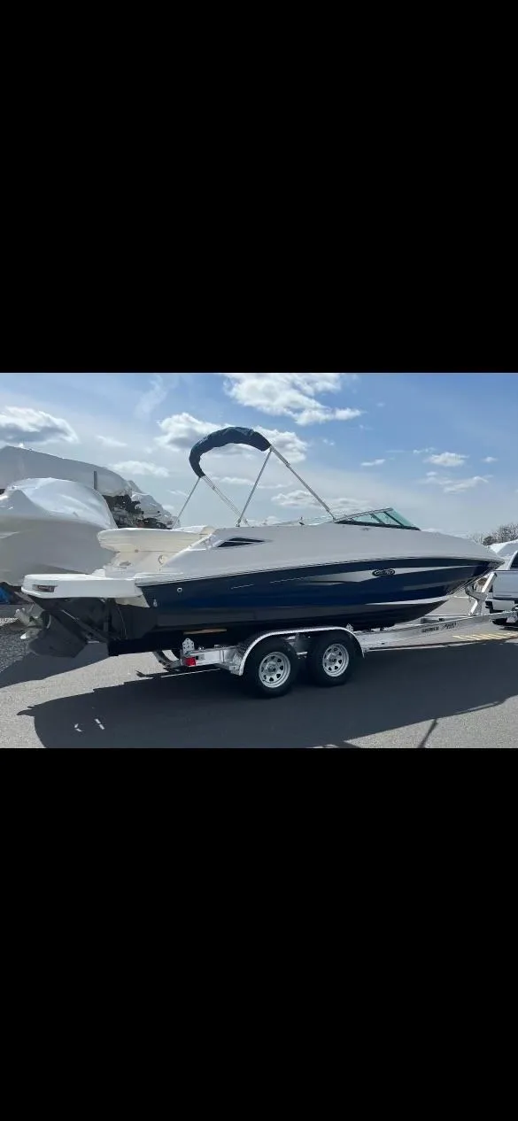 Slide: The Image of 2014 Sea Ray 240 Sundeck boat on a trailer under a clear sky. - 10