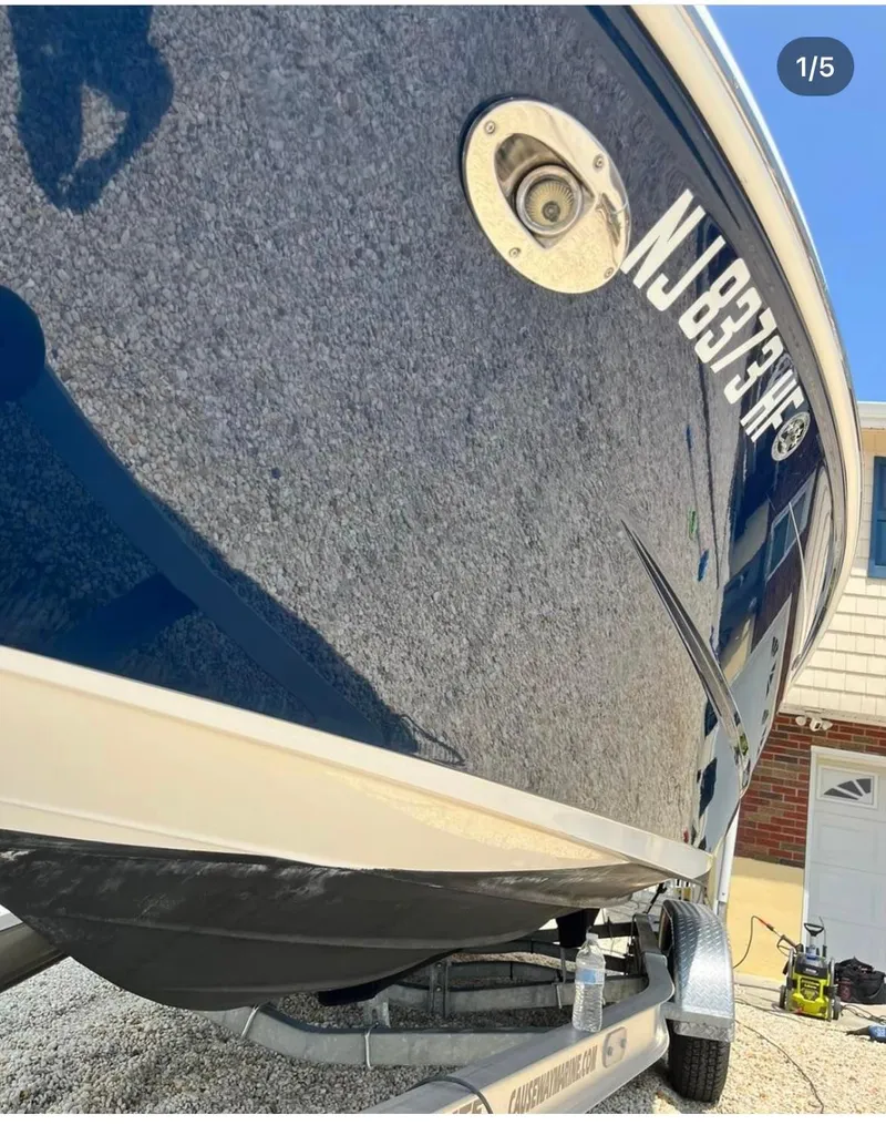 Slide: The Image of 2014 Sea Ray 240 Sundeck boat on a trailer, close-up view of hull and registration number. - 2