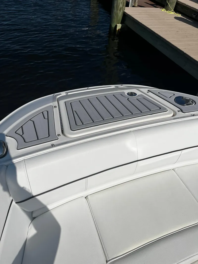 Slide: The Image of 2014 Sea Ray 240 Sundeck boat at dock, featuring cushioned seating and deck. - 4