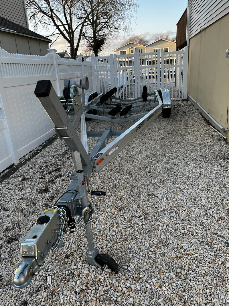 Slide: The Image of 2014 Sea Ray 240 Sundeck boat trailer parked on gravel driveway. - 8