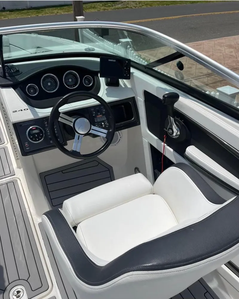 Slide: The Image of 2014 Sea Ray 240 Sundeck boat cockpit with steering wheel and control panel. - 9