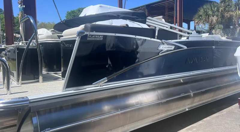 Slide: The Image of 2024 Avalon Catalina Quad Lounge pontoon boat with Mercury engine, docked outdoors. - 1