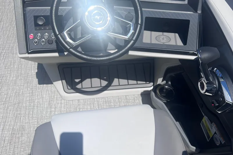 Slide: The Image of 2024 Avalon Catalina Quad Lounge 23' boat dashboard with steering wheel and controls. - 15