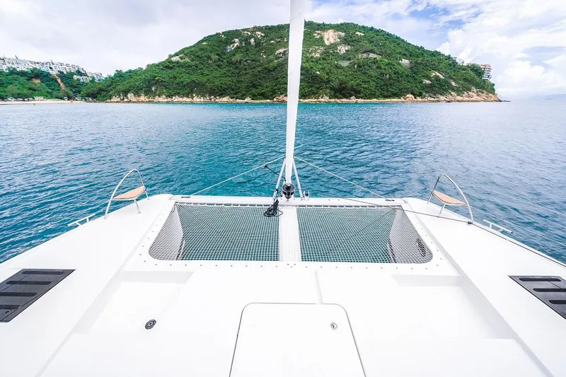 Slide: The Image of Front deck of 2024 Fountaine Pajot Tanna 47 catamaran with scenic island view. - 12