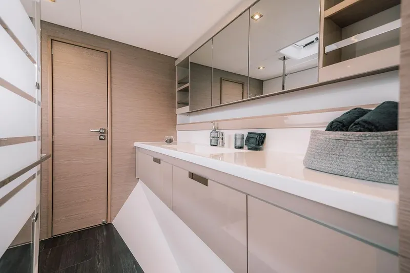 Slide: The Image of Modern bathroom in 2024 Fountaine Pajot Tanna 47 catamaran with sleek cabinetry and large mirrors. - 6