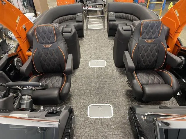 Slide: The Image of 2024 Bennington 27 QXFBWA T2 interior with luxurious black and orange seating. - 12