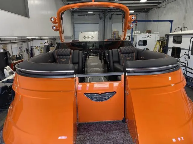 Slide: The Image of 2024 Bennington 27 QXFBWA T2 pontoon boat with orange exterior in a showroom. - 29