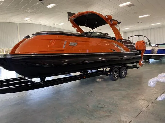 Slide: The Image of 2024 Bennington 27 QXFBWA T2 pontoon boat with orange and black exterior. - 3