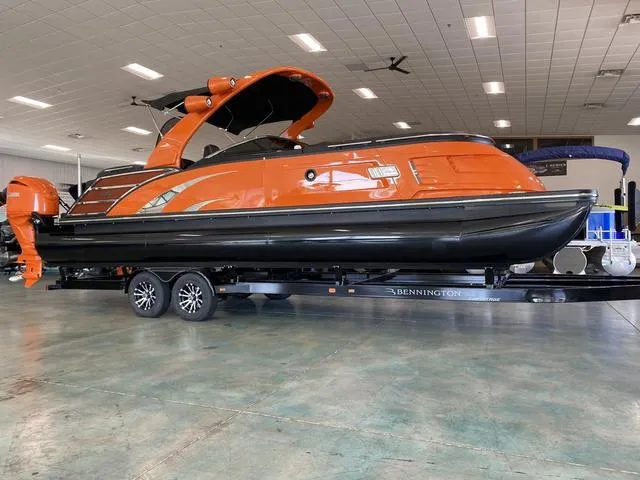 Slide: The Image of 2024 Bennington 27 QXFBWA T2 pontoon boat in vibrant orange on display indoors. - 31