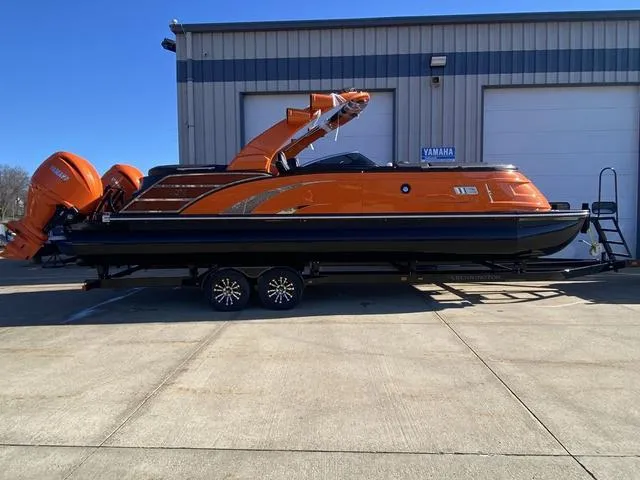 Slide: The Image of 2024 Bennington 27 QXFBWA T2 boat with dual orange outboard motors in a garage. - 6