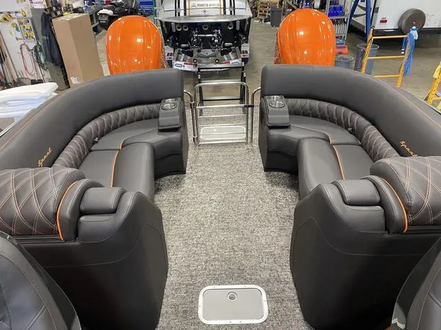 Slide: The Image of 2024 Bennington 27 QXFBWA T2 luxury pontoon boat interior with plush seating and orange accents. - 8