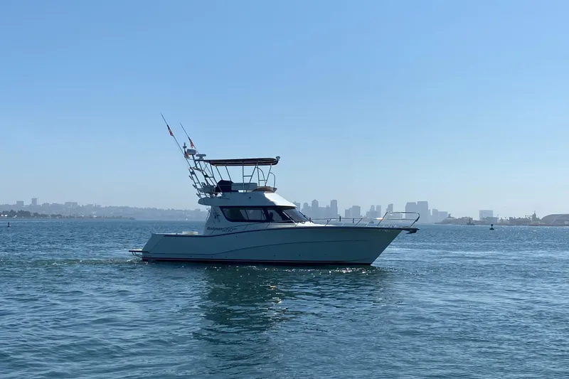 Slide: The Image of 2014 Rodman 1250 ADV Fisher Cruiser on calm waters with city skyline in background. - 10