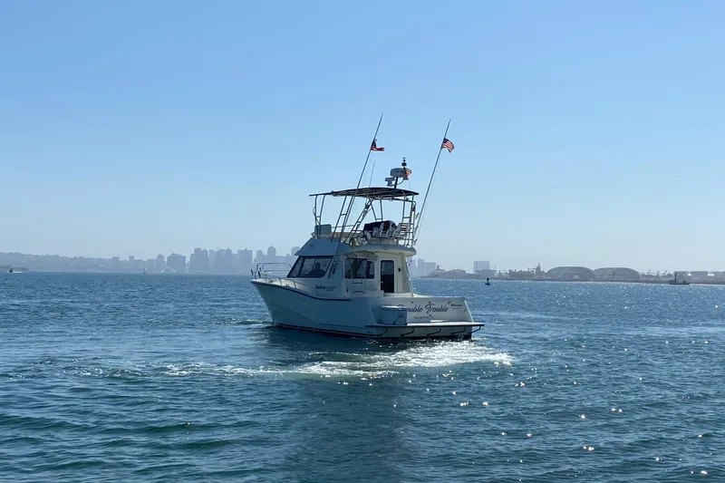Slide: The Image of 2014 Rodman 1250 ADV Fisher Cruiser on open water with city skyline in background. - 13
