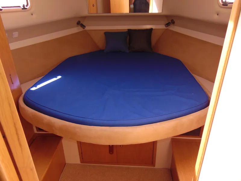 Slide: The Image of 2014 Rodman 1250 ADV Fisher Cruiser cabin with blue bed and wooden storage. - 14