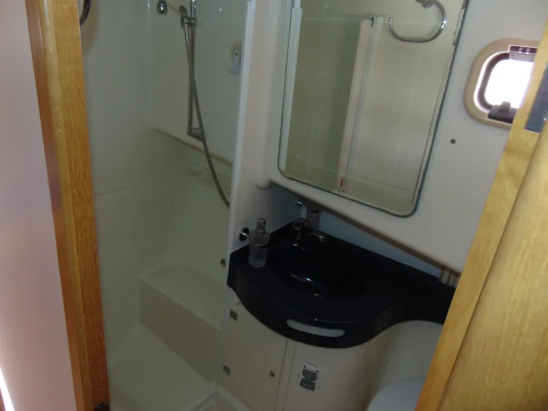 Slide: The Image of Compact bathroom in 2014 Rodman 1250 ADV Fisher Cruiser with shower, sink, and mirror. - 16
