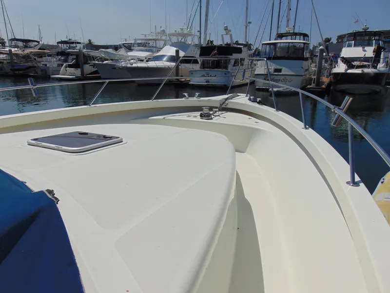 Slide: The Image of Bow view of a 2014 Rodman 1250 ADV Fisher Cruiser docked at a marina. - 2