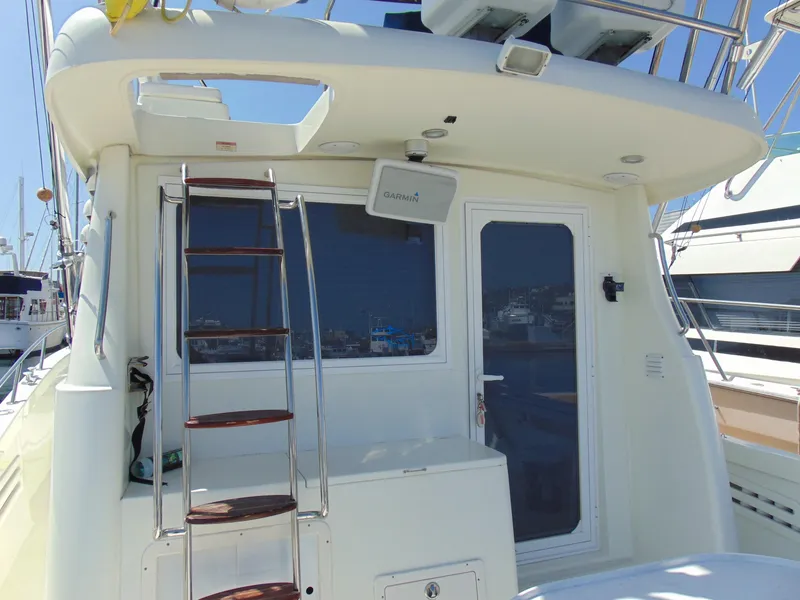 Slide: The Image of Rodman 1250 ADV Fisher Cruiser 2014, rear view with ladder and door, docked at marina. - 28
