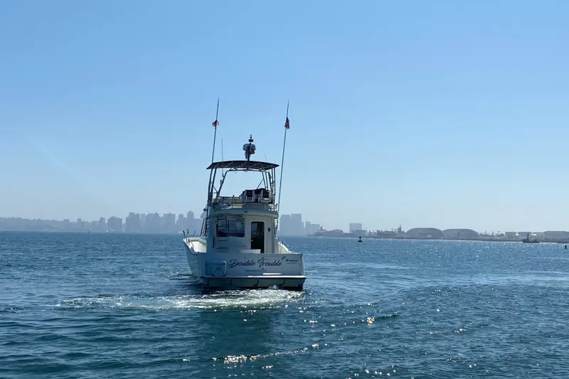 Slide: The Image of Rodman 1250 ADV Fisher Cruiser 2014 on open water with city skyline in background. - 3