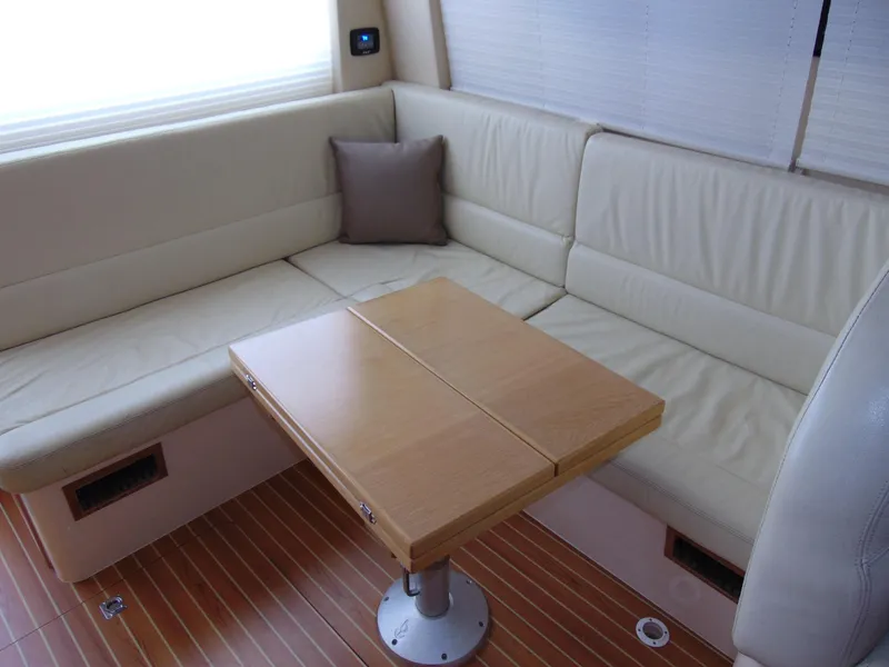 Slide: The Image of Rodman 1250 ADV Fisher Cruiser 2014 interior with beige seating and wooden table. - 6