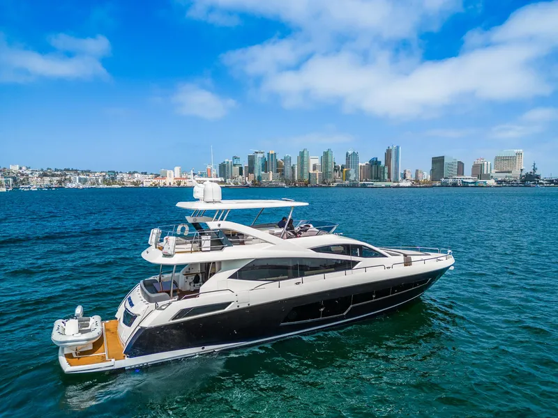 Slide: The Image of 2014 Sunseeker 75 Yacht cruising near a city skyline on a sunny day. - 0