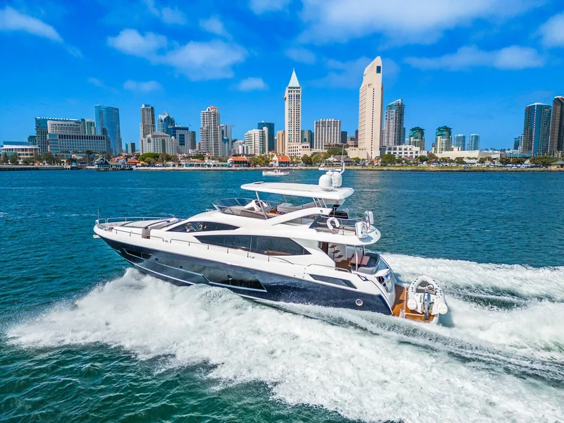Slide: The Image of 2014 Sunseeker 75 Yacht cruising near a city skyline. - 16
