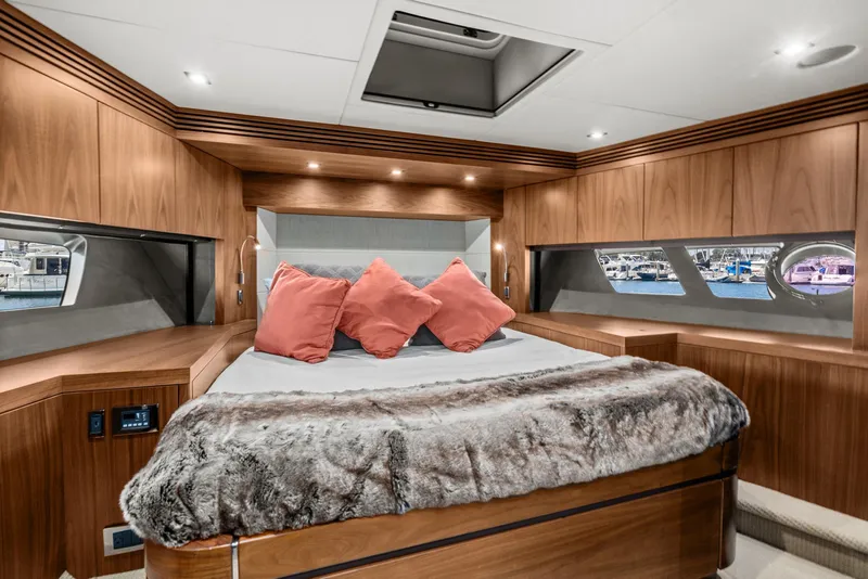 Slide: The Image of Luxurious master bedroom in a 2014 Sunseeker 75 Yacht with wood paneling and plush bedding. - 21