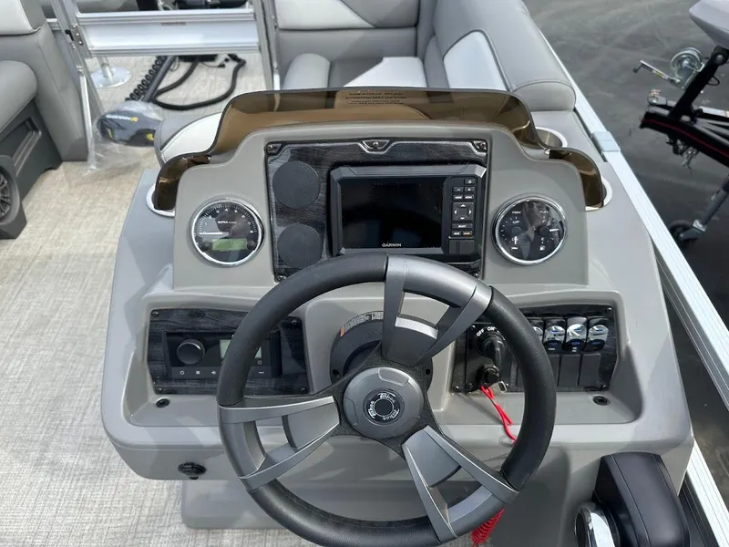 Slide: The Image of 2024 Tahoe Pontoon Sport Cruise Bow Fish dashboard with steering wheel and controls. - 21
