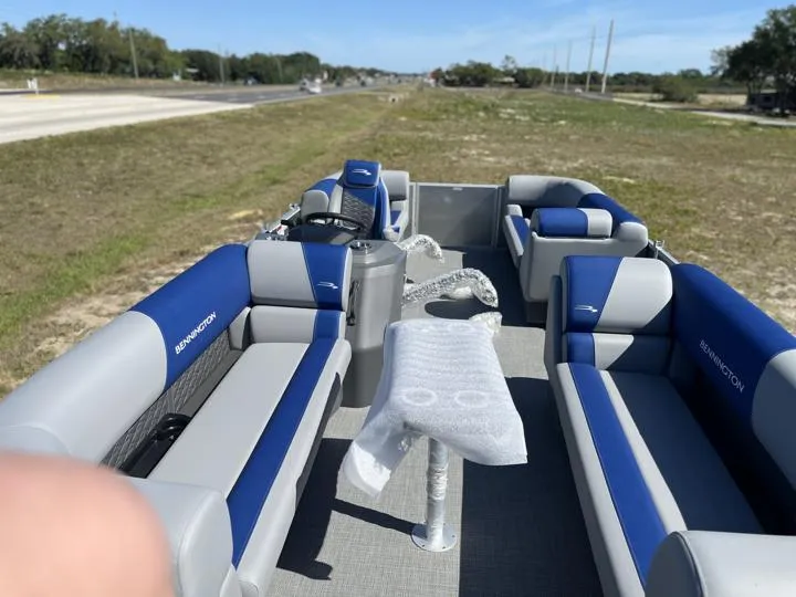 Slide: The Image of 2024 Bennington S 20 SSR pontoon boat with blue and gray seating on a sunny day. - 12