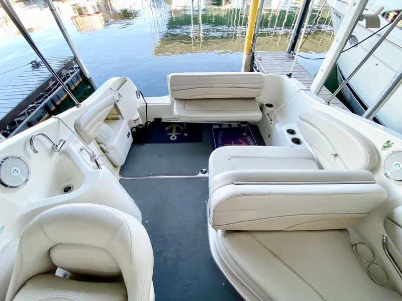 Slide: The Image of 2008 Larson Cabrio 240 boat interior with white leather seating and dock view. - 12