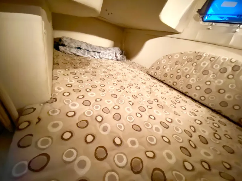 Slide: The Image of 2008 Larson Cabrio 240 cabin bed with patterned bedding. - 18