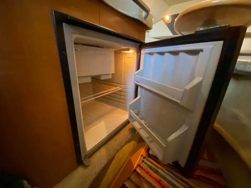 Slide: The Image of Open refrigerator inside 2008 Larson Cabrio 240 boat cabin. - 21